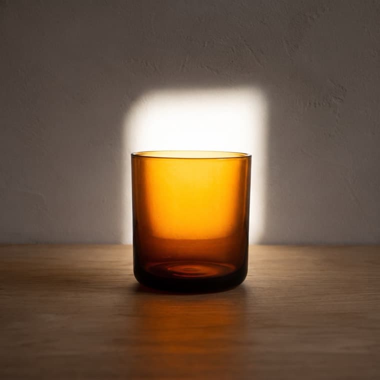 Water Glass 250 ml in amber, photographed under backlit by window: bright window directly behind the object.