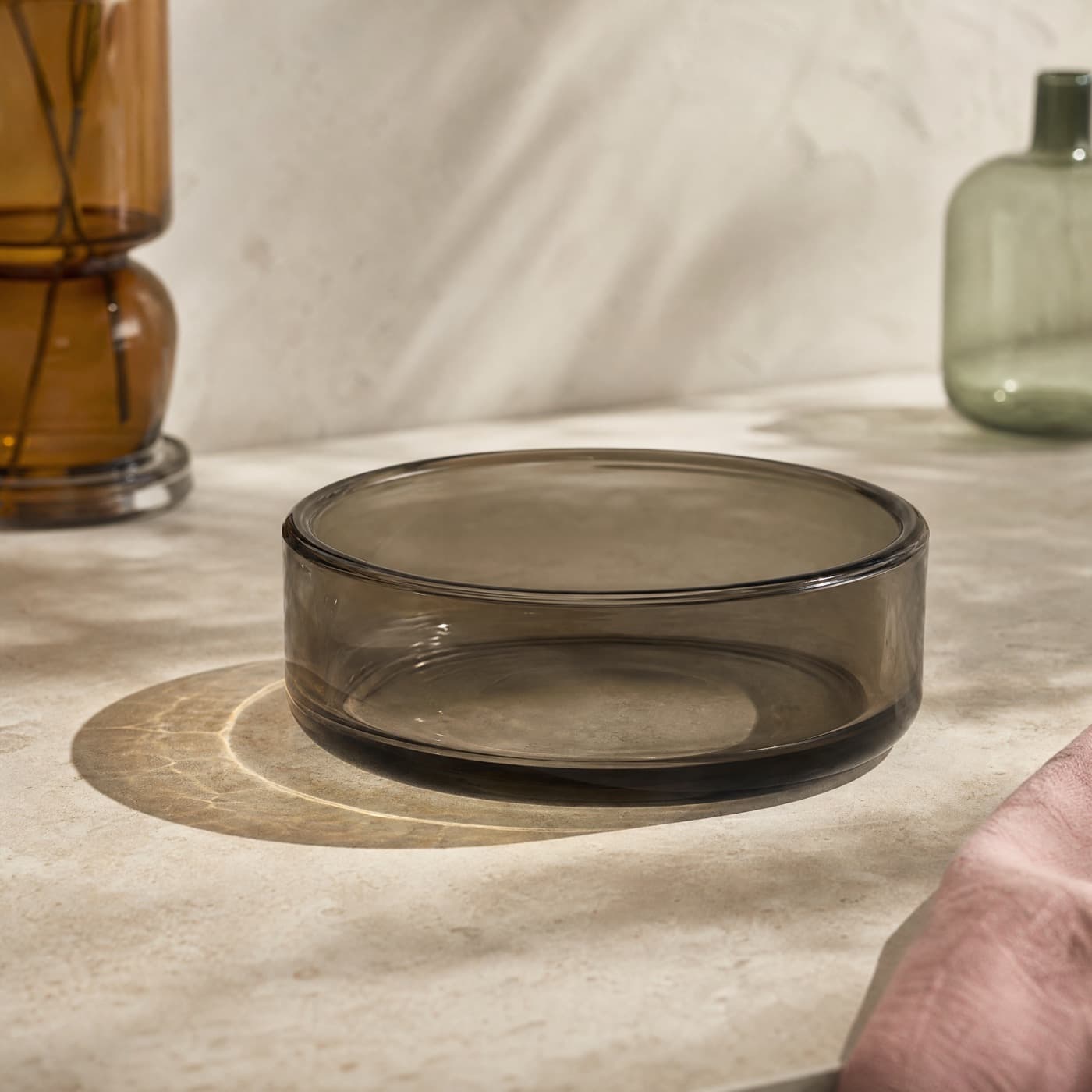 Smoke-grey borosilicate deep dish on a kitchen counter in flat daylight.