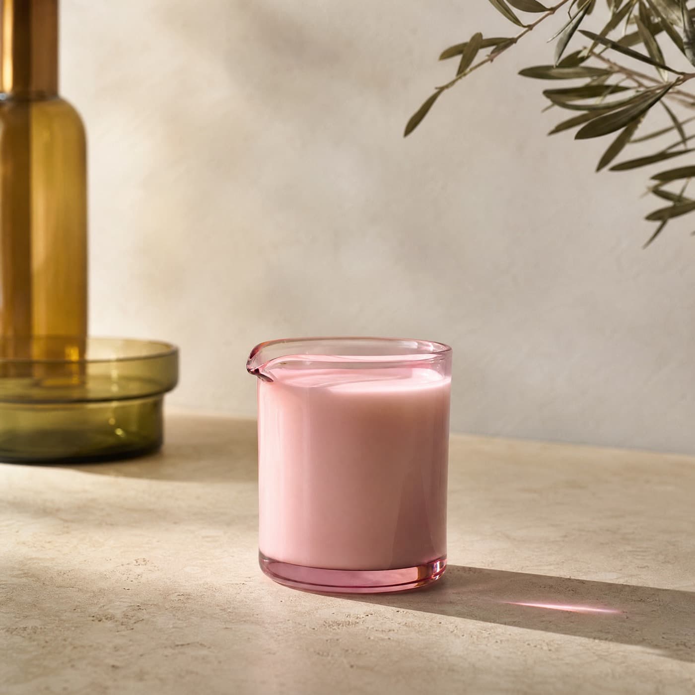 Misty rose milk jug filled with milk on a breakfast table in morning light.